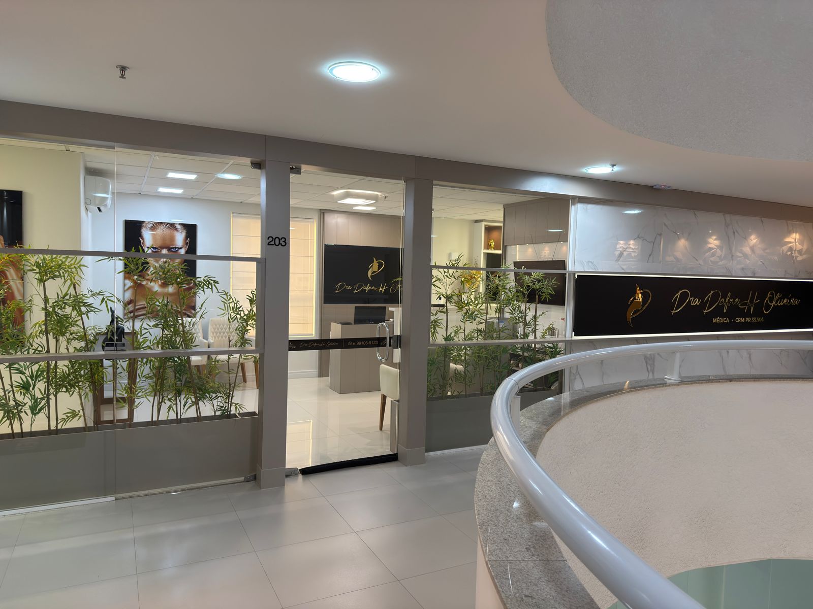 Entrada da sala 203 com recepção e fachada em preto e dourado