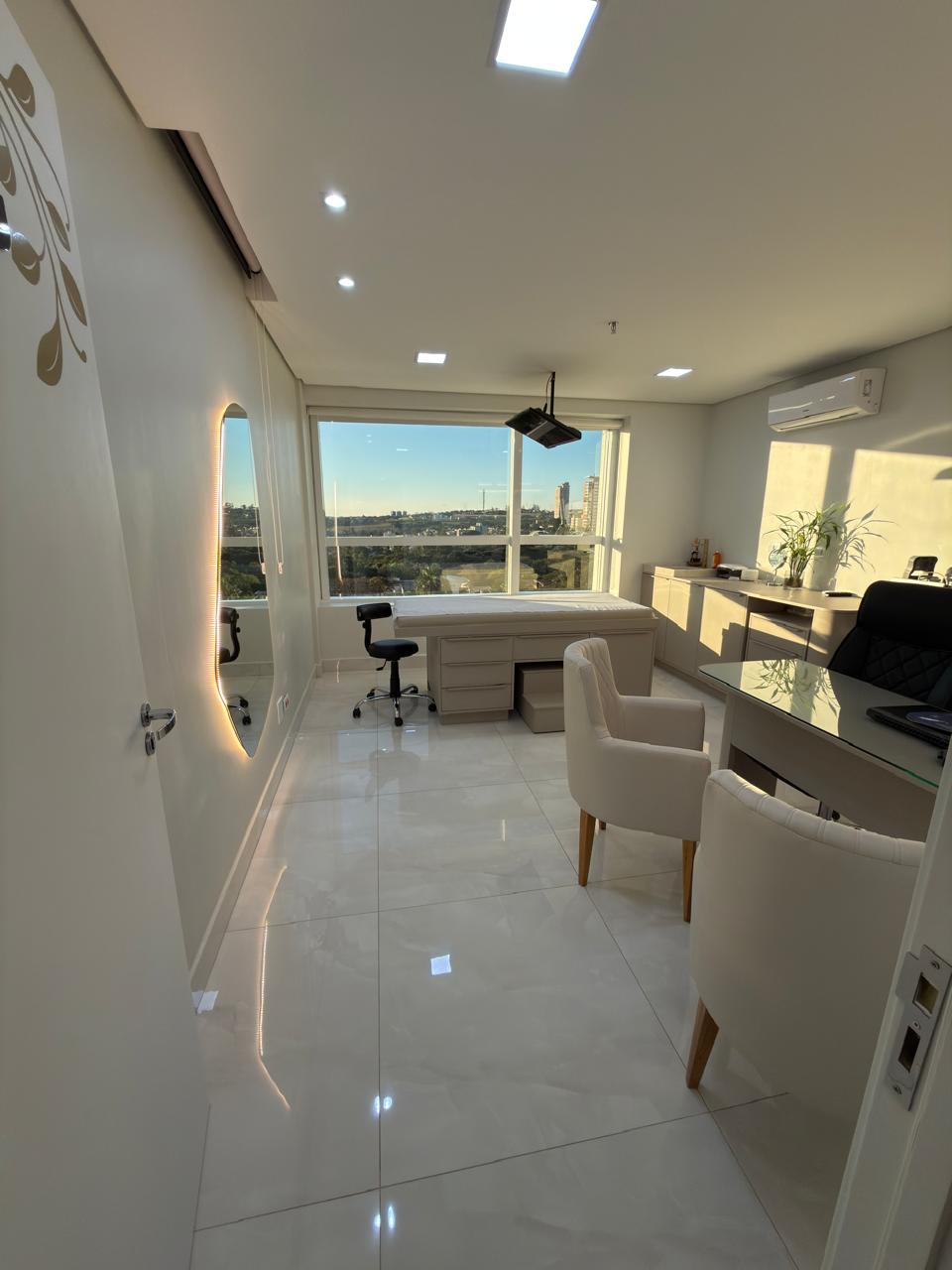 Consultório com maca, vista panorâmica e mesa de atendimento